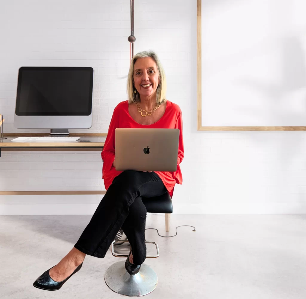 Kathi Burns, CPO, smiling at her desk with her laptop